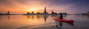 Kayaker on Chao Phraya River at sunrise.