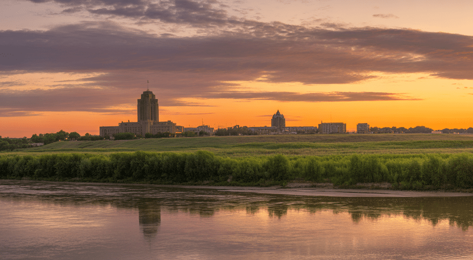 Bismarck North Dakota skyline at sunset over river.
